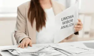 Kobieta w marynarce przegląda dokumenty z napisem "Umowa WIBOR Analiza".