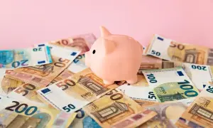 Różowa świnka-skarbonka na stosie banknotów euro. Zastanawiasz się nad boś bank konto oszczędnościowe oprocentowanie?