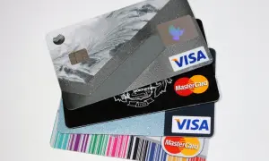 Stos kart kredytowych Visa i Mastercard z różnymi wzorami.