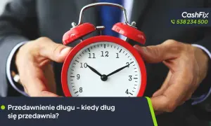 Dłoń trzyma czerwony budzik, symbolizując czas. Kiedy przedawnia się dług w firmie windykacyjnej? Sprawdź, jak działa termin przedawnienia.