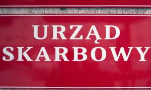 Czerwona tablica z białym napisem "URZĄD SKARBOWY". Współwłaściciel konta bankowego a urząd skarbowy - ważne sprawy podatkowe.