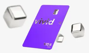Fioletowa karta Vivid Visa Debit z błyszczącym logo, otoczona metalicznymi sześcianami. Wiele pozytywnych vivid money opinie potwierdza jej funkcjonalność.