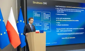 Mężczyzna przemawia przy mównicy, obok flagi Polski i UE. Na ekranie struktura OKI, inwestycje, lokaty, obligacje oszczędnościowe, rachunek oszczędnościowy plus opłaty.
