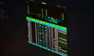 Monitor z danymi finansowymi, gdzie widać wykresy i liczby. Prawdopodobnie dane z funduszu hedgingowego.