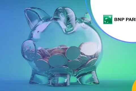 Przezroczysta skarbonka w kształcie świnki wypełniona monetami, logo BNP Paribas.