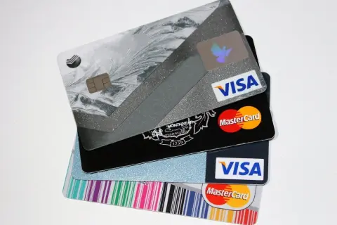 Stos kart kredytowych Visa i Mastercard z różnymi wzorami.