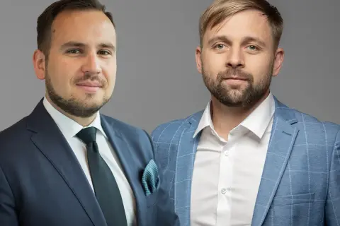 Dwóch mężczyzn w garniturach, gotowych doradzić, w co zainwestować 50 tys.