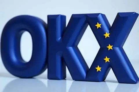 Niebieskie litery OKX z żółtymi gwiazdkami, symbolizujące Europę. Wiele osób szuka okx crypto opinie przed inwestycją.