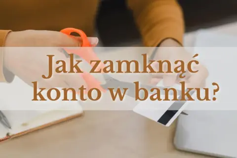 Ręce przecinające nożyczkami kartę bankową na tle laptopa i notatnika.