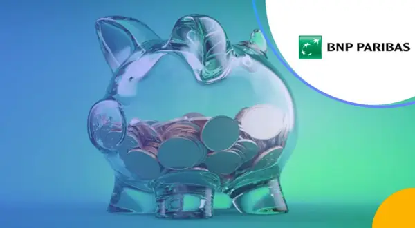 Przezroczysta skarbonka w kształcie świnki wypełniona monetami, logo BNP Paribas.