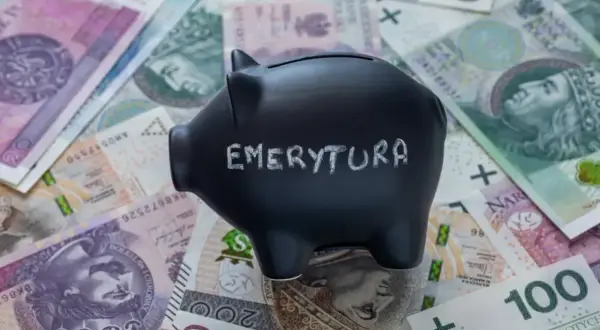 Czarna skarbonka z napisem "EMERYTURA" na tle polskich banknotów.