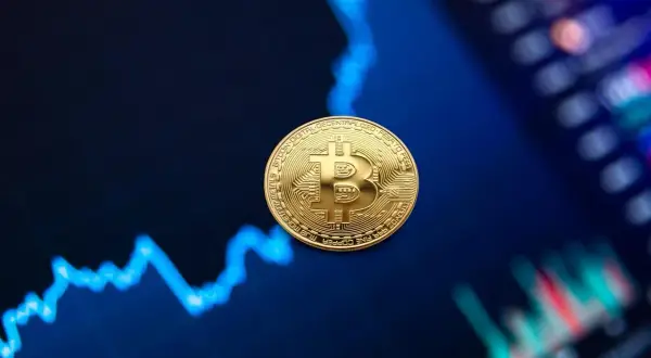 Złota moneta Bitcoin na tle wykresu finansowego.