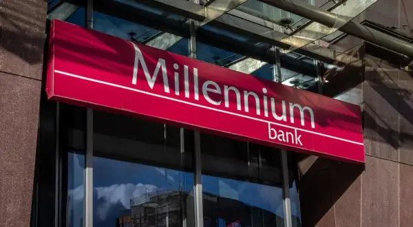 Znak banku Millennium. Słońce odbija się od fasady, tworząc cienie. Może to być miejsce, gdzie dokonano millennium przelew z konta oszczędnościowego.