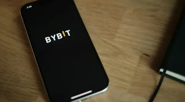 Smartfon z logo Bybit na ekranie. Zastanawiasz się nad **Bybit prowizje**? Sprawdź je na swoim urządzeniu.
