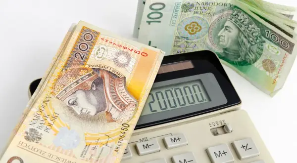 Kalkulator pokazuje 200 000, a obok leżą banknoty 200 i 100 zł. Zastanawiasz się, jaka rata kredytu 50 tys. Cię czeka?