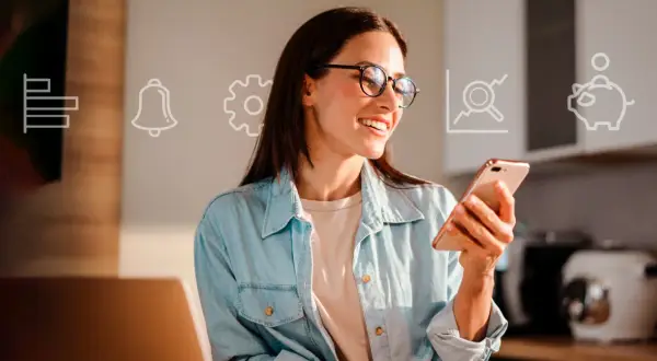 Uśmiechnięta kobieta w okularach trzyma smartfon, na tle ikony finansowe: wykres, dzwonek, koło zębate, lupa, skarbonka.