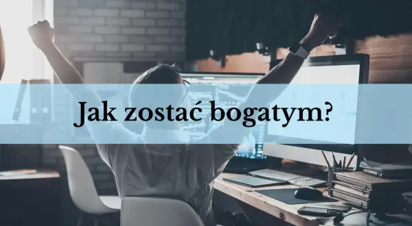 Mężczyzna z rękami w górze siedzi przy biurku z komputerem, na którym widać wykresy.