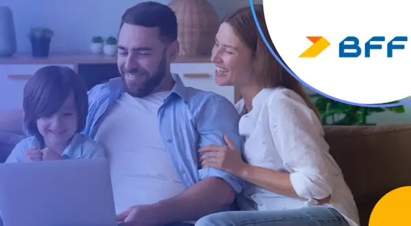 Rodzina ogląda coś na laptopie, uśmiechnięta. Logo BFF w rogu.