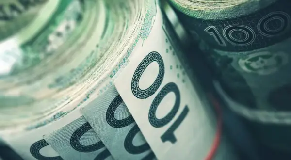 Zrolowane banknoty 100 zł, symbolizujące dużą wartość nominalną obligacji.