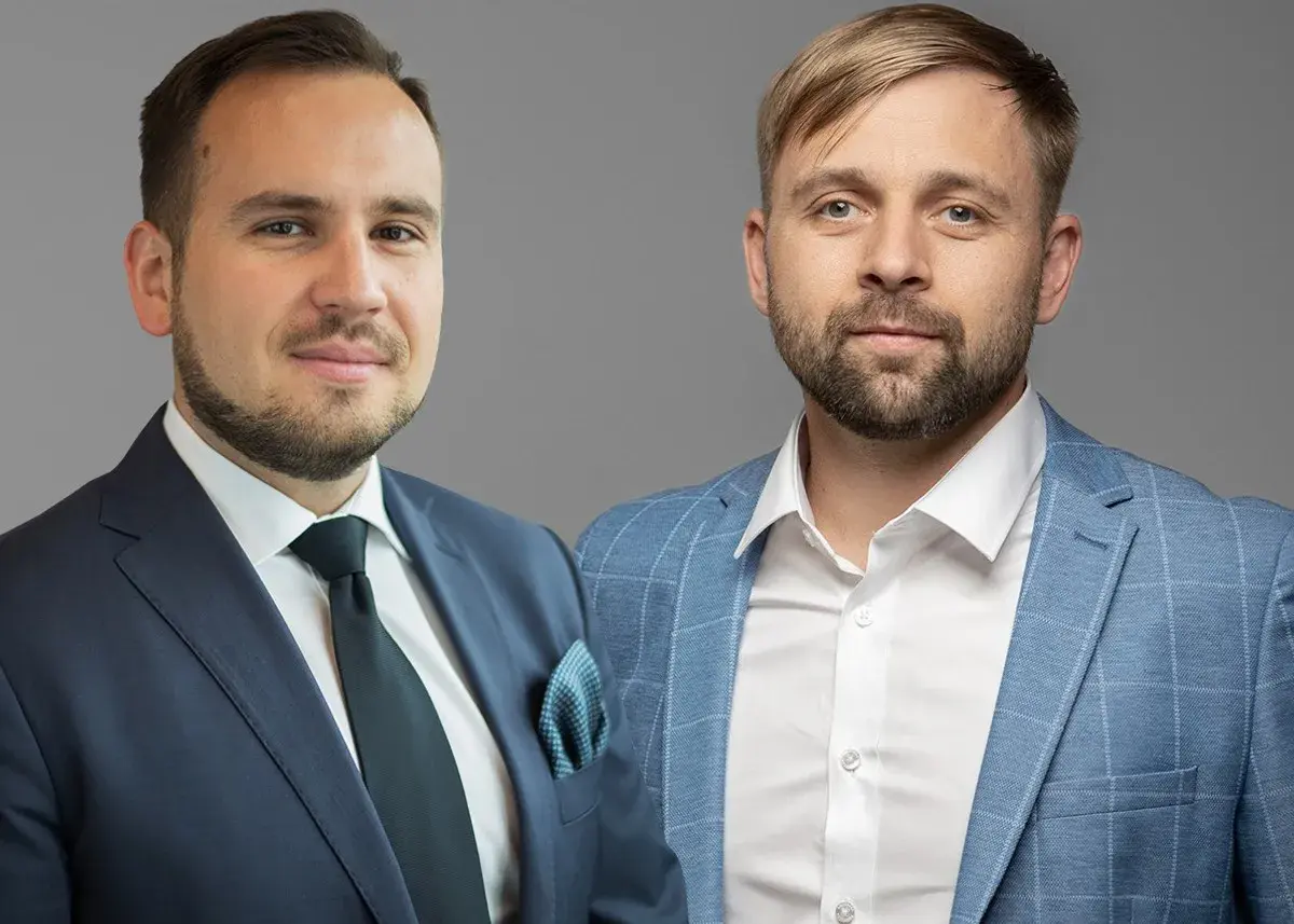 Dwóch mężczyzn w garniturach, gotowych doradzić, w co zainwestować 50 tys.