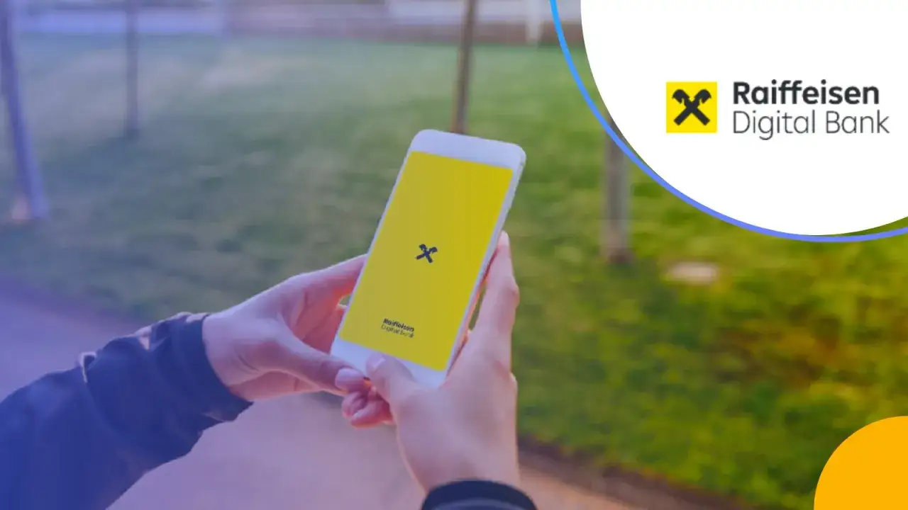 Dłonie trzymają smartfon z logo Raiffeisen Digital Bank.