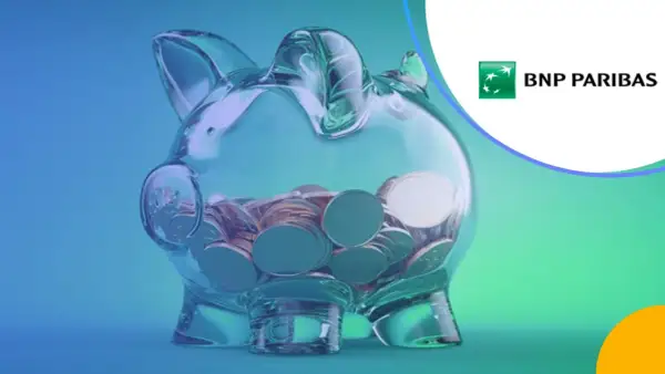 Przezroczysta skarbonka w kształcie świnki wypełniona monetami, logo BNP Paribas.