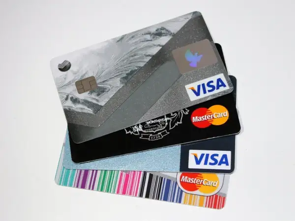 Stos kart kredytowych Visa i Mastercard z różnymi wzorami.