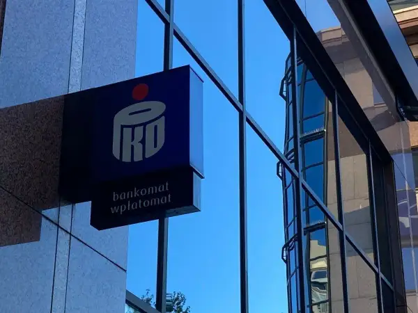 Logo PKO z napisem "bankomat wpłatomat" na tle szklanej fasady budynku. Idealne miejsce na szybkie przelewy przychodzące PKO.