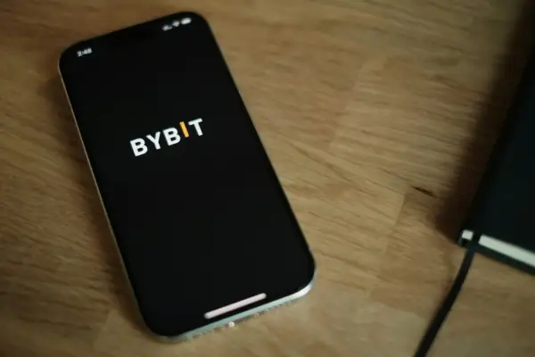 Smartfon z logo Bybit na ekranie. Zastanawiasz się nad **Bybit prowizje**? Sprawdź je na swoim urządzeniu.