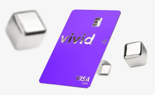 Fioletowa karta Vivid Visa Debit z błyszczącym logo, otoczona metalicznymi sześcianami. Wiele pozytywnych vivid money opinie potwierdza jej funkcjonalność.