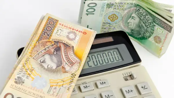 Kalkulator pokazuje 200 000, a obok leżą banknoty 200 i 100 zł. Zastanawiasz się, jaka rata kredytu 50 tys. Cię czeka?