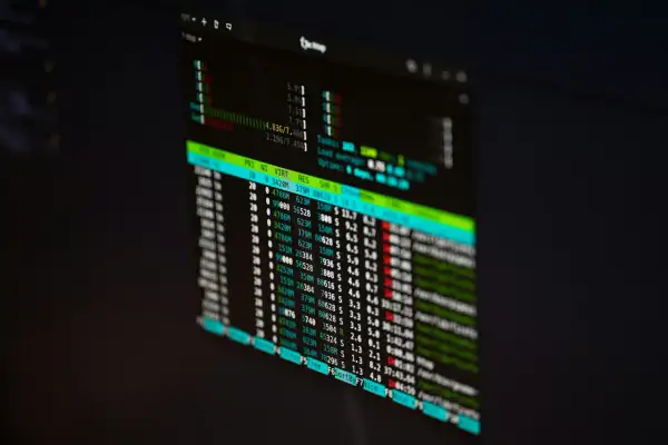 Monitor z danymi finansowymi, gdzie widać wykresy i liczby. Prawdopodobnie dane z funduszu hedgingowego.