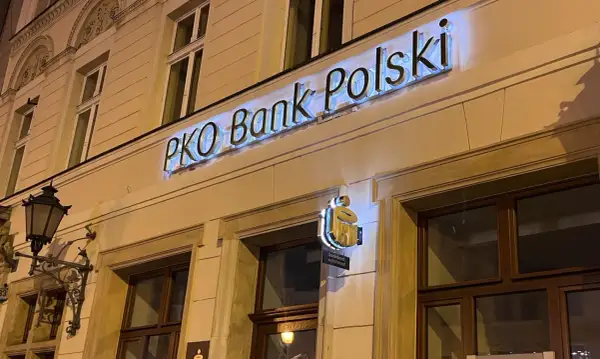 Neony z napisem "PKO Bank Polski" na fasadzie budynku.